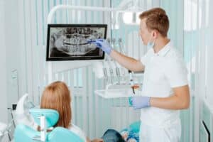 Woman having a consult with her dentists during her bi-annual teeth cleaning.