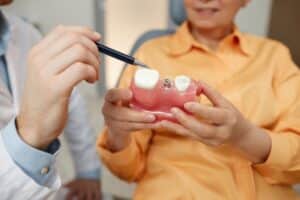Dentist explaining to a patient what their dental options are, whether keeping the natural tooth is preferred.