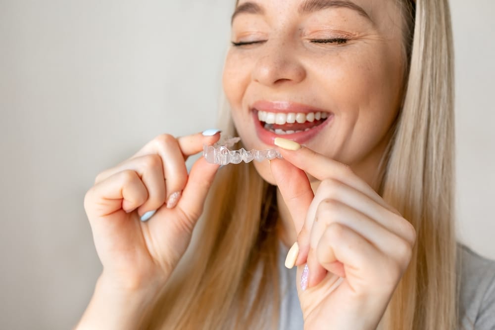 Woman putting in an Invisalign® Go aligner in Omaha, NE